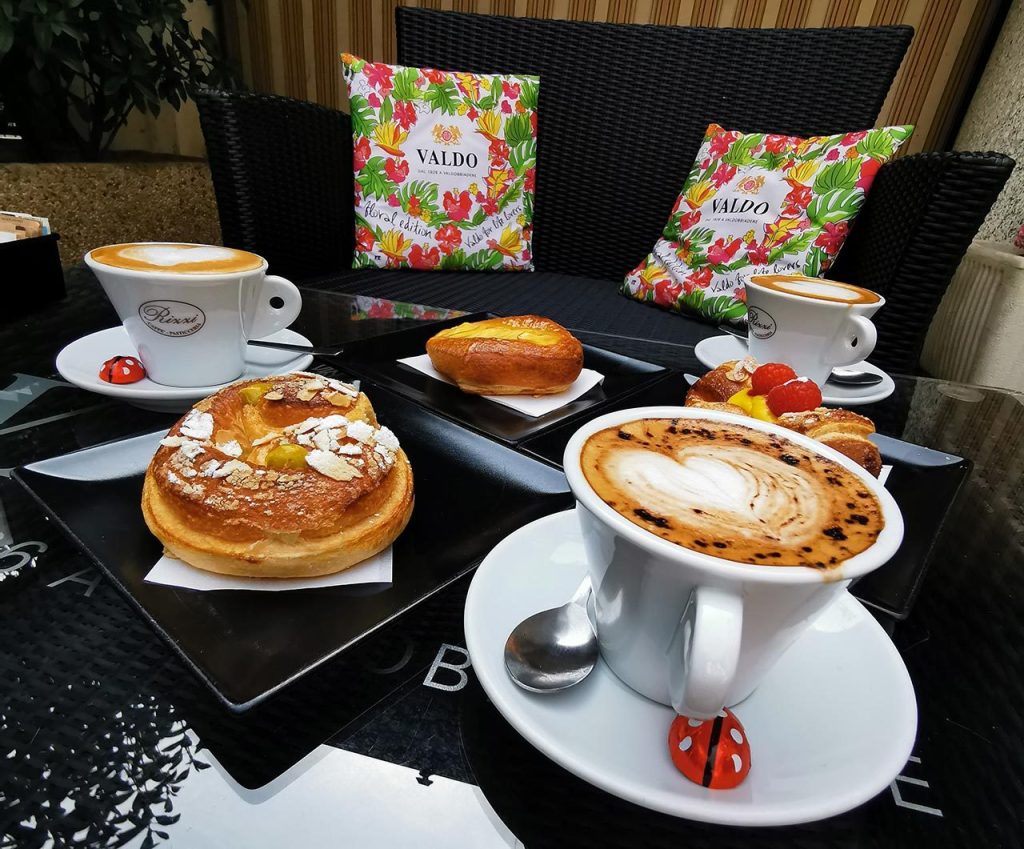 Colazione al tavolino: cappuccini, brioche e dolci