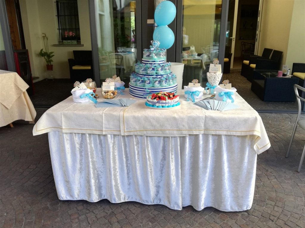 Tavolo di un rinfresco per battesimo con torta a piani azzurra