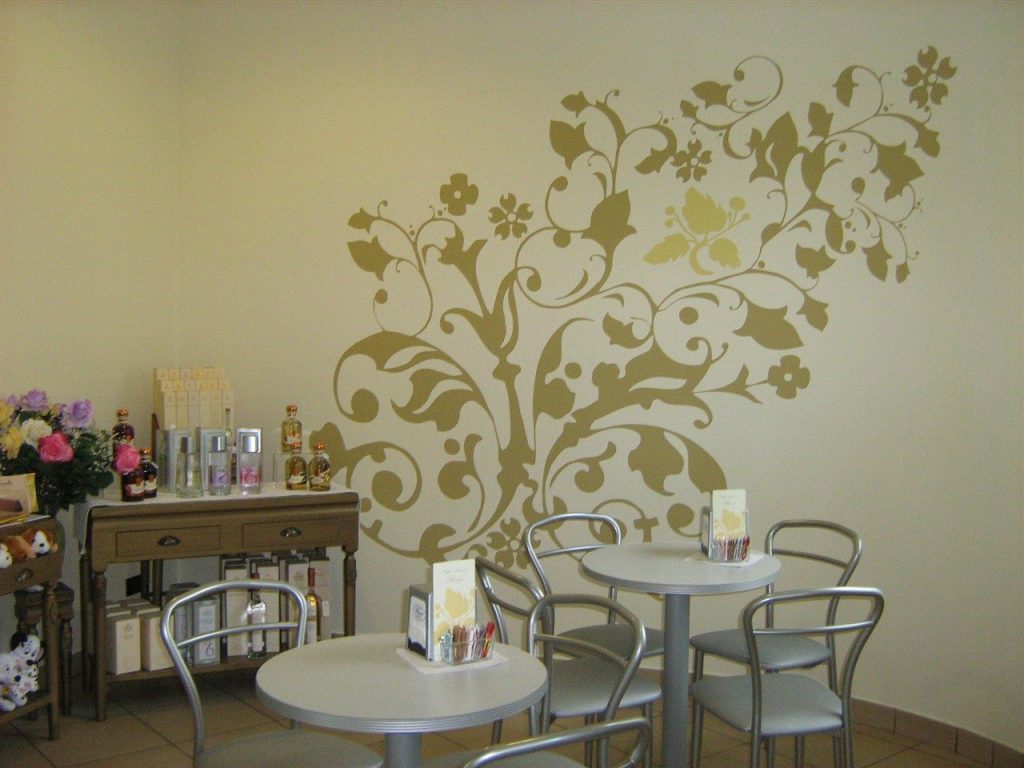 Sala da tè con tavolini e decorazione floreale sulla parete