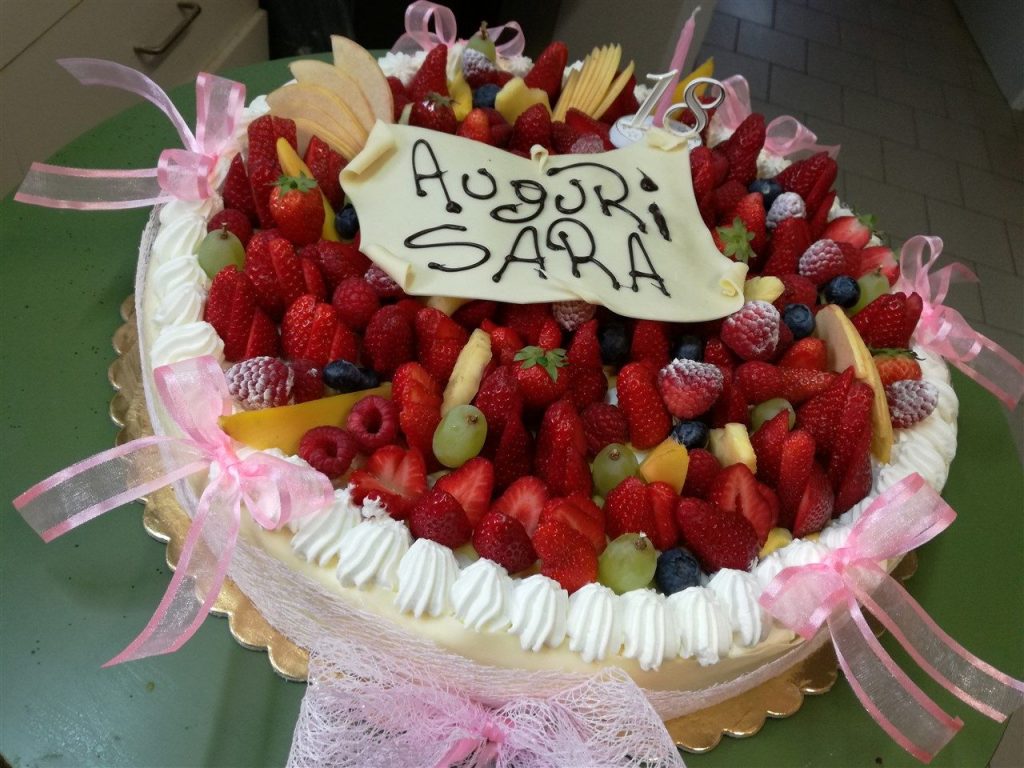 Torta alla frutta fresca con scritta Auguri Sara e nastri rosa